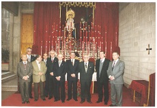 Hermanos veteranos y hermanos mayores delante del altar de los Titulares.